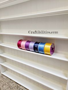 the shelves are painted white with different colors and designs on them, along with decorative tape