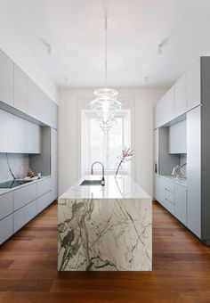 a kitchen with marble counter tops and wooden floors