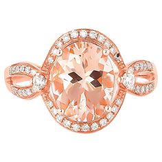 a ring with an oval shaped peach colored stone surrounded by diamonds