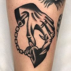 a tattoo on the leg of a person holding hands with chains and sun above them