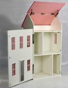 a doll house with a pink roof and two windows on the top floor is open