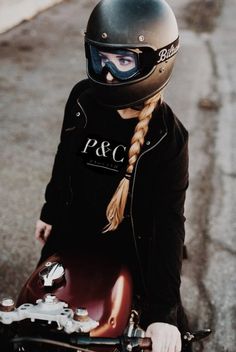 a person with a helmet sitting on a skateboard in the street and wearing a jacket