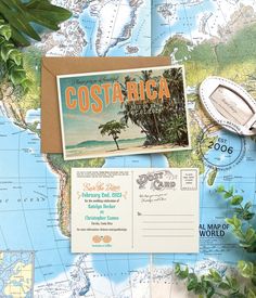 an old postcard sits on top of a map with stamps and other items around it