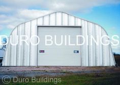 a large metal building sitting in the middle of a field