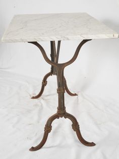 a marble top table with ornate iron legs