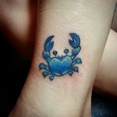 a small blue crab tattoo on the wrist