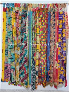 many different types of scarves hanging on a wall