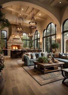 a living room filled with lots of furniture next to large windows and a fire place