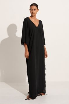 The Saas dress features Caravana's signature knot detailing with a deep v neckline and 3/4 sleeves. Fringe hem. Elegant V-neck Dress With Tassels, Black 3/4 Sleeve Beach Dress, Black Beach Dress With 3/4 Sleeve, Chic Black V-neck Kaftan, Elegant Maxi Dress With 3/4 Sleeves For Beach, Elegant Half Sleeve Maxi Dress For Beach, V Neckline, Black Maxi Dress, Deep V