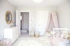 a baby's room with white walls and gold accents