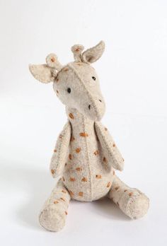 a stuffed giraffe sitting on top of a white surface