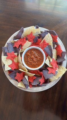 a plate filled with chips and salsa on top of a wooden table