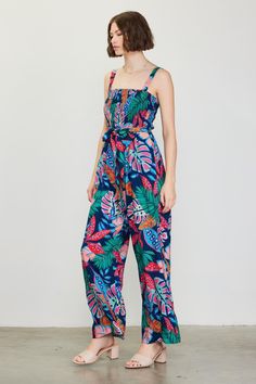 Fun, colorful, and impossible to ignore in a tropical floral print, this strappy jumpsuit is the ideal way to spice up your warm-weather wardrobe. It's got a smocked bodice that's balanced by a wide, roomy cut through the legs. A self-tie belt completes the look. "•Gathered shoulder straps •Smocked bodice •Ruffle trim at neckline •Optional self-tie belt •Wide-leg silhouette Item Number: 74403 SELF: 80% RAYON 20% NYLONE LINING: 100% RAYON Vacation Dresses Casual, Wedding Guest Dress Trends, Strappy Jumpsuit, Belt Wide, Tropical Floral Print, Casual Wedding Dress, Vacation Dresses, Sweater Sale, Tropical Floral