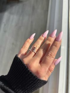 a woman's hand with pink manies and a ring on her finger, in front of a window