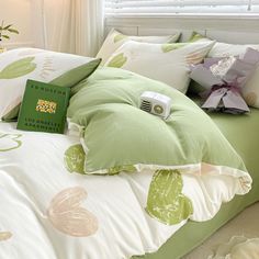 a green and white bed with pillows and a camera