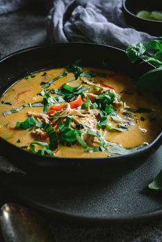 a black bowl filled with soup on top of a table