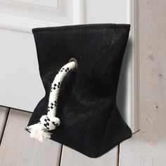 a black and white bag with a tassel hanging from it's front door