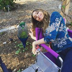 a woman sitting in a wheel chair next to two birds