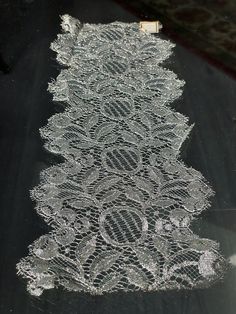 an intricately designed lace is displayed on the floor