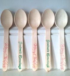 six wooden spoons are lined up in a row, with the words merry christmas written on them