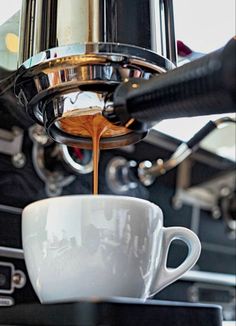 coffee being poured into a white cup