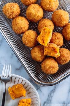 some food is sitting on a metal rack and next to a plate with one bite taken out of it