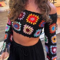 Elevate your style with this stunning Long Sleeves Crop Top, a perfect blend of comfort and chic fashion. This crochet crop sweater is a masterpiece of craftsmanship, featuring vibrant sunburst granny square patterns in a multicolor design. Ideal for a boho chic look, this patchwork top is a must-have for festival outfits and casual wear alike. Handmade with love, this unique piece combines traditional crochet techniques with modern fashion trends. The intricate patchwork and rich colors make it a standout addition to any wardrobe. Whether you're heading to a festival, a casual day out, or looking for a thoughtful handmade gift, this top is your go-to choice. Handmade crochet design Long sleeves for added comfort Sunburst granny square multicolor pattern Boho chic patchwork style Perfect f Cheap Spring Crochet Top With Granny Square, Crochet Top Made Of Squares, Crochet Granny Square Top With Sleeves, Granny Square Long Sleeve Top Pattern, Bohemian Crochet Top For Winter, Trending Crop Top Designs, Crochet Tshirt Outfits, Crochet Granny Square Sleeves, Winter Crochet Tops