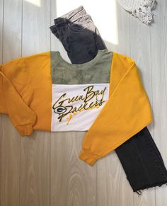 "NFL Green Bay Packers color-block Crewneck Rework  Style: Crewneck Colors: Green, yellow, & white. Graphic: NFL Green Bay Packers Size: Best fitting MEDIUM  Measurements are all taken laying flat Pit to pit: 24\" Length: 23\" Model pictured is xs-s, 5'2 for reference This is a sustainable, 1 of 1 product that was upcycled & handcrafted by 2nd hand material.  Madsew'n ♻️ Instagram & TikTok: Madsew.n Fb page: Madsew'n" Casual Yellow Tops With Splicing, Yellow College Sweatshirt For Fall, Yellow Color Block Tops For Fall, Yellow Long Sleeve Top With Contrast Color, Yellow Color Block Sweatshirt For Fall, Casual Yellow Tops For Game Day, Casual Yellow Spliced Top, Yellow Crew Neck Top For Game Day, Casual Yellow Patchwork Tops