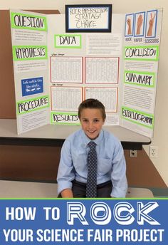 a boy sitting in front of a rock science fair project