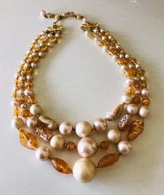 This swirly golden brown glass and cream colored light weight bright bead necklace features three layers of variegated light weight beads. The shortest layer is 16 1/2 inches including the adjustable bead chain. The long layer is 18inches. There is a small adjustable 3 inch chain with hook clasp in the back. The hook is signed Japan. The biggest focal bead is 5/8 inch wide. This is a fun layered vintage choker in good condition. These necklaces can be short for some people. Be sure to measure yo Long Layer, Vintage Choker, Bead Chain, Long Layers, Copper Bracelet, Bright Gold, Hook Clasp, Focal Bead, Golden Brown