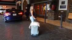 a woman pushing a luggage cart through an airport