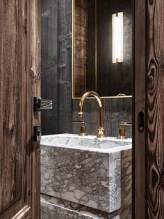 a bathroom sink sitting under a mirror next to a wooden door