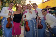 a group of women standing next to each other holding musical instruments