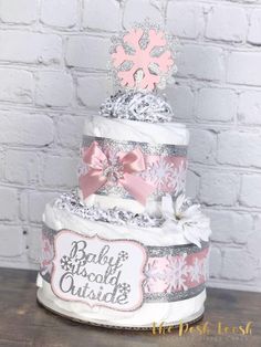 a three tiered diaper cake decorated with pink and silver snowflakes