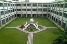 the courtyard of an apartment building with green lawn and white sculptures in the center area