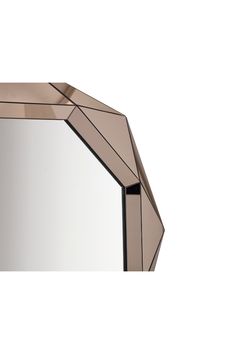 a mirror that is sitting on top of a white surface and has geometric shapes around it