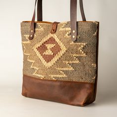 a brown and tan tote bag sitting on top of a table