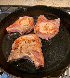 two pieces of meat cooking in a frying pan