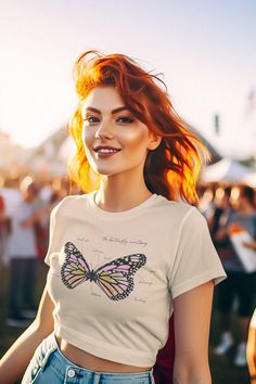 a woman with red hair wearing a butterfly t - shirt