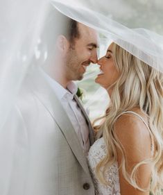 a bride and groom kissing under a veil