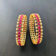 2.8,2.6 size CZ Bangles/Sabyasachi Bangles/Cubic Zirconia Ruby Bangles/Indian Bridal Jadau Bangles/CZ Bangles/Punjabi Wedding Bangles/Bollywood Features Traditional Cubic Zirconia and Pink stones bangles Set Handcrafted To Perfection Light Weight Perfect For Indian Weddings And Celebrations A Beautiful & Memorable Gift for Weddings and Special Occasions Available in 2.6,2.8 size The base metal color is Gold tone brass studded with colorful semi-precious stones on it. Pair of 2 bangles For mo Traditional Bangle With Tilla For Reception, Traditional Heavy Bangle For Reception, Festive Traditional Bangle With American Diamond, Festive American Diamond Round Bangle, Traditional Stone Work Bangle For Reception, Traditional Bangle For Reception And Festivals, Traditional American Diamond Bangle For Festive Occasions, Diwali Celebration Bangle With Zari Work, Bollywood Style Kundan Bangle For Reception