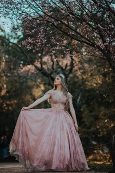 a woman in a pink dress is posing for the camera with her hands on her hips