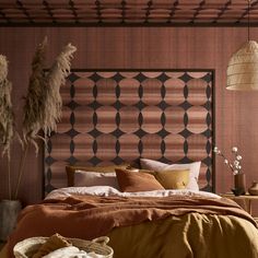 a bed with brown sheets and pillows next to a wooden headboard in a bedroom