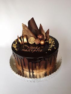 a chocolate cake with gold decorations on top