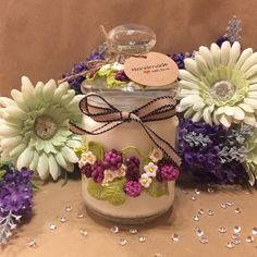 a jar filled with lots of flowers sitting on top of a table next to some purple and white flowers