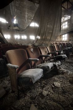 an abandoned auditorium with several chairs in it