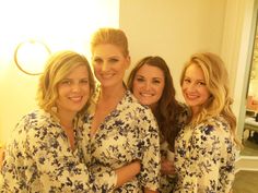 three women in matching robes posing for the camera with their arms wrapped around each other