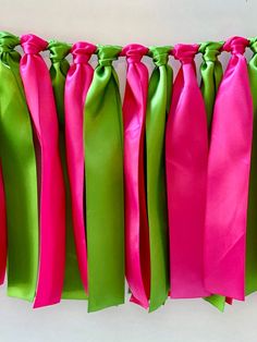 pink and green ribbons are hanging on the wall