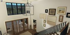 an aerial view of a staircase with pictures on the wall and framed photos on the walls