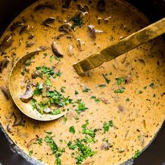 a bowl of soup with mushrooms and parsley in it